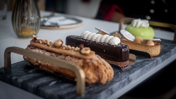 Assortiment d'éclairs et d'entremets sur un plateau en marbre