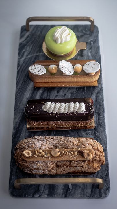 Plateau de pâtisseries vu du dessus : entremets, tartelette et éclairs