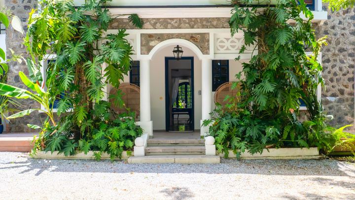 Entrée d'une villa entourée de végétation tropicale